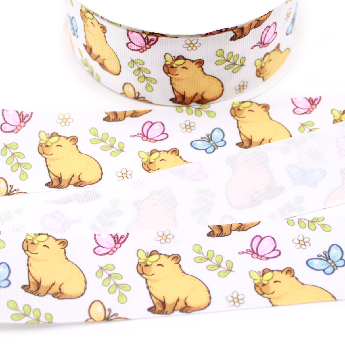 Capybara and Butterflies printed grosgrain ribbon with cute capybaras, pink and blue butterflies, flowers and green leaves on a white background.