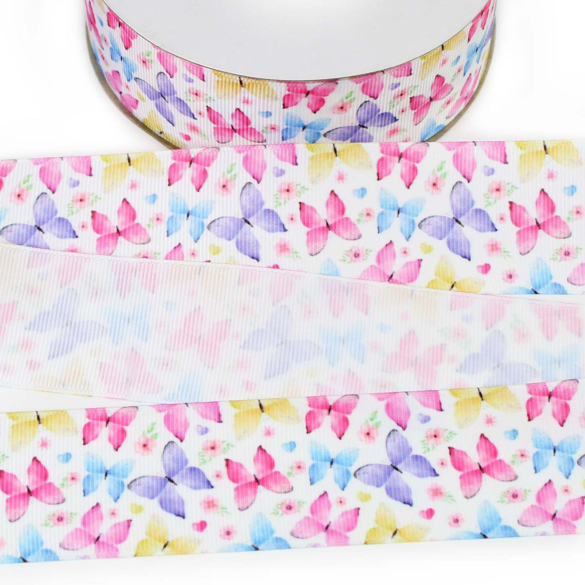 Butterfly printed grosgrain ribbon featuring watercolor-style pink, purple, blue and yellow butterflies with small flowers on a white background.