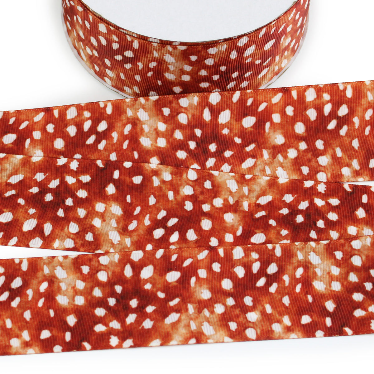 Deer fur printed grosgrain ribbon with rusty brown and tan coloring and scattered white fawn spots.