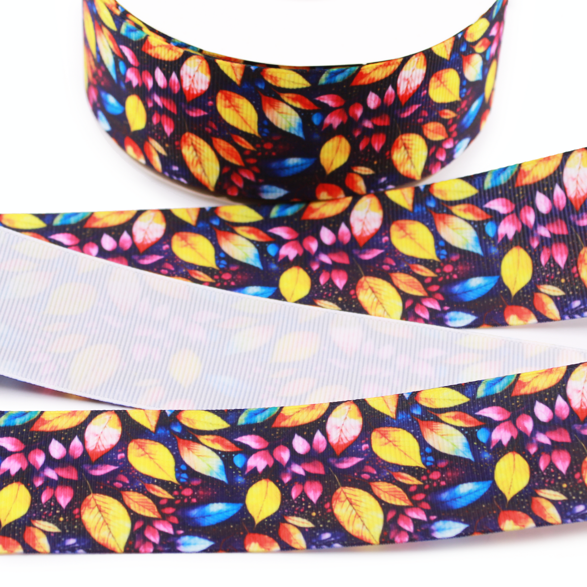 Colorful fall leaves printed grosgrain ribbon with yellow, orange, pink and blue leaves on a dark background.