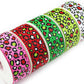 Christmas Leopard printed grosgrain ribbon with black leopard spots accented in red, green and white on pink, red, green, lime and white backgrounds.