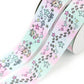 Winter Wishes printed grosgrain ribbon with cute reindeer, stars, flowers and playful doodles on a pastel pink, mint and blue background.